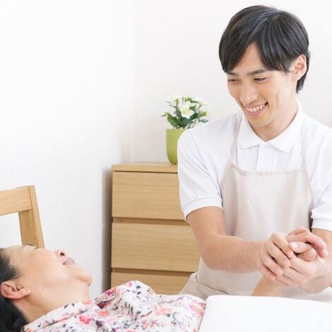 女性の手を握る男性スタッフ